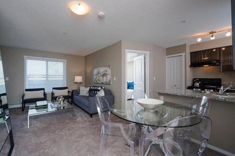 A living room with a glass table and chairs.