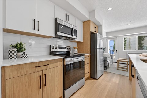 A modern kitchen with wooden cabinets and stainless steel appliances.