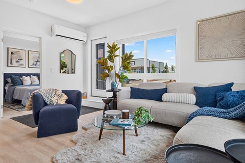 A living room with a blue chair and a grey couch.