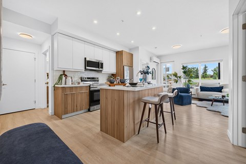 A modern kitchen with wooden cabinets and a bar area.