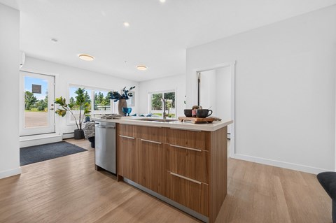 A kitchen with a white counter top and wooden cabinets.