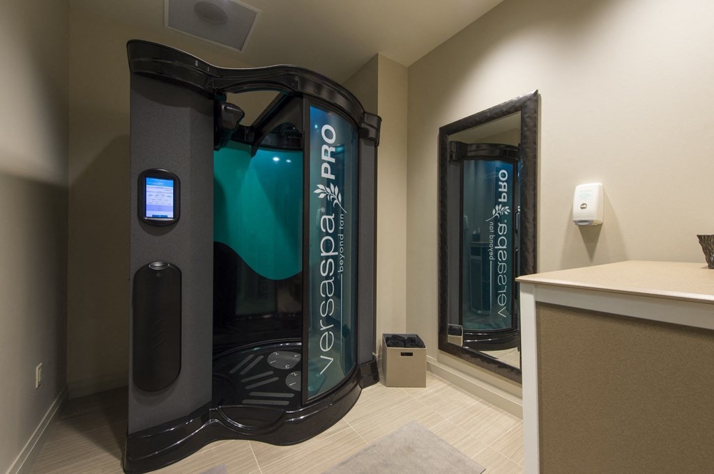 a room with a spray tan booth in the middle of it