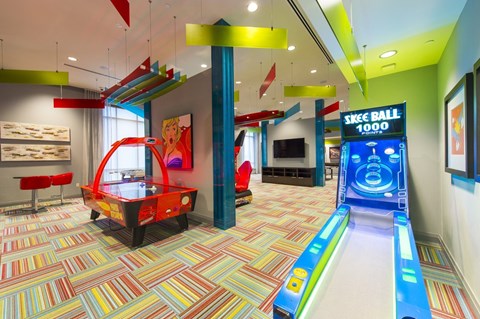 a game room with an air hockey table and a skee ball machine