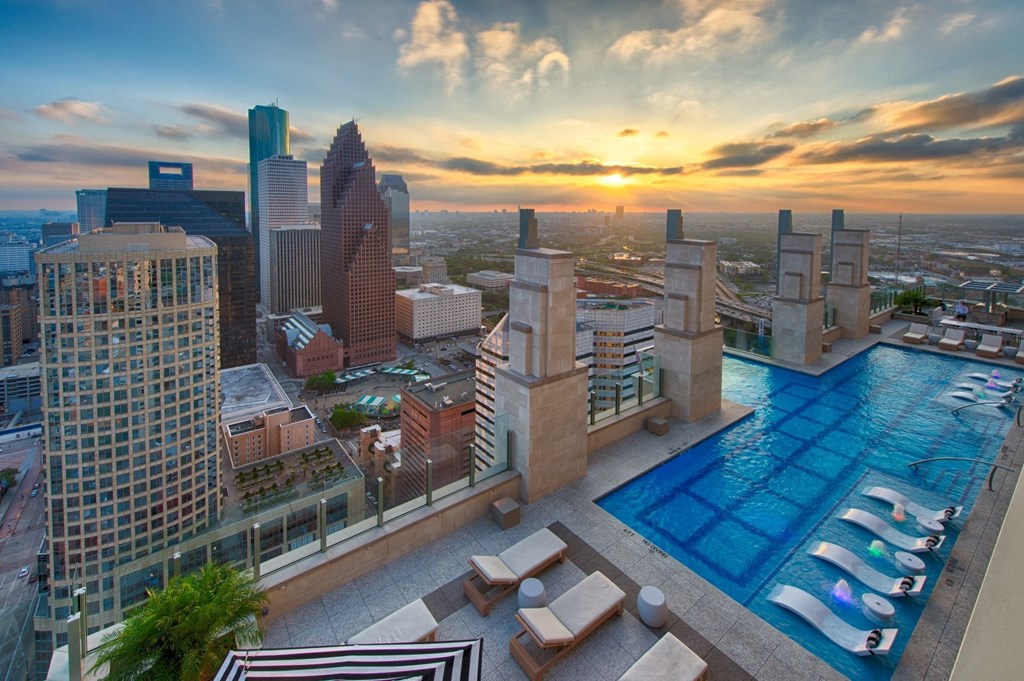 a view of the downtown Houston skyline with a rooftop pool with glass bottom in the foreground at market square tower