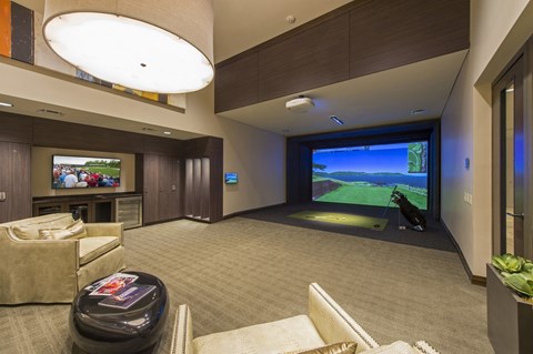 a large room with projector and large screen for golf simulator