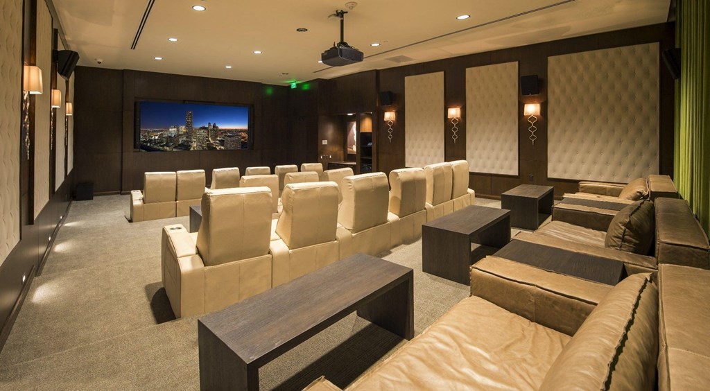 a movie theater room with large leather chairs and a large movie screen
