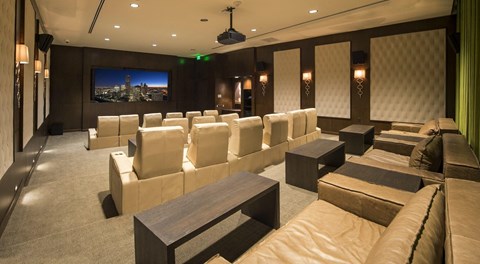 a movie theater room with large leather chairs and a large movie screen