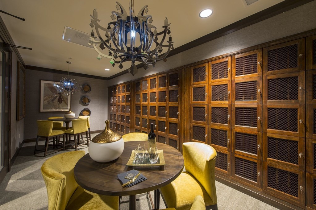 wine storage lockers with a round table and yellow chairs