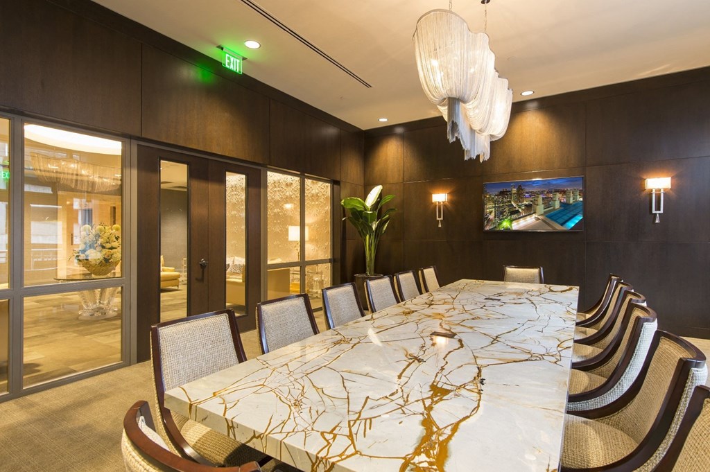 a large table with chairs and a tv in a room with glass doors