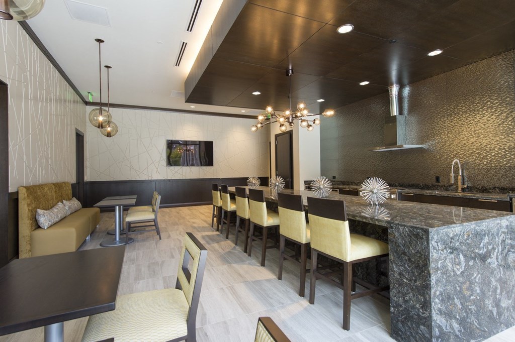 a view of the demonstration kitchen and with seating at a long granite countertop at market square tower in downtown houston