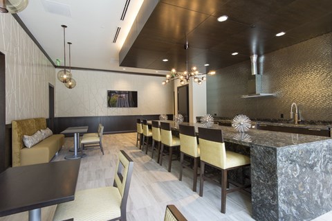 a view of the demonstration kitchen and with seating at a long granite countertop at market square tower in downtown houston