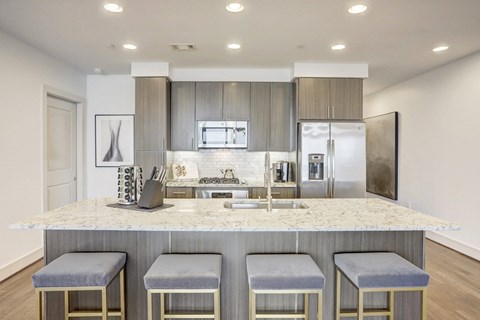 a kitchen with a large island with four stools in front of it