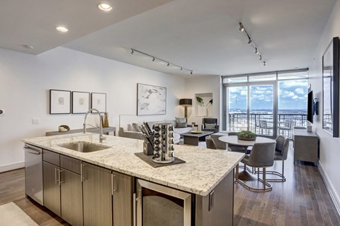 a kitchen and living room with a large window and an expansive sky view at market square tower in downtown houston
