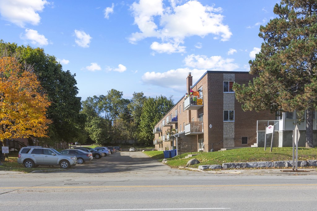 a building on the corner of a street with a parking lot in front of it