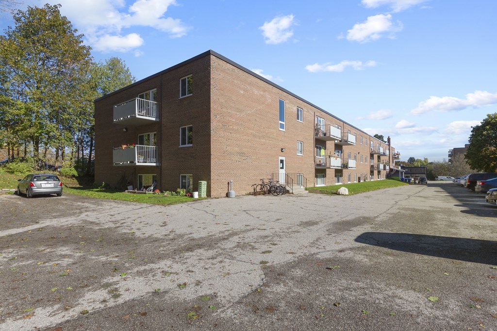 a large brick apartment building with a parking lot in front of it