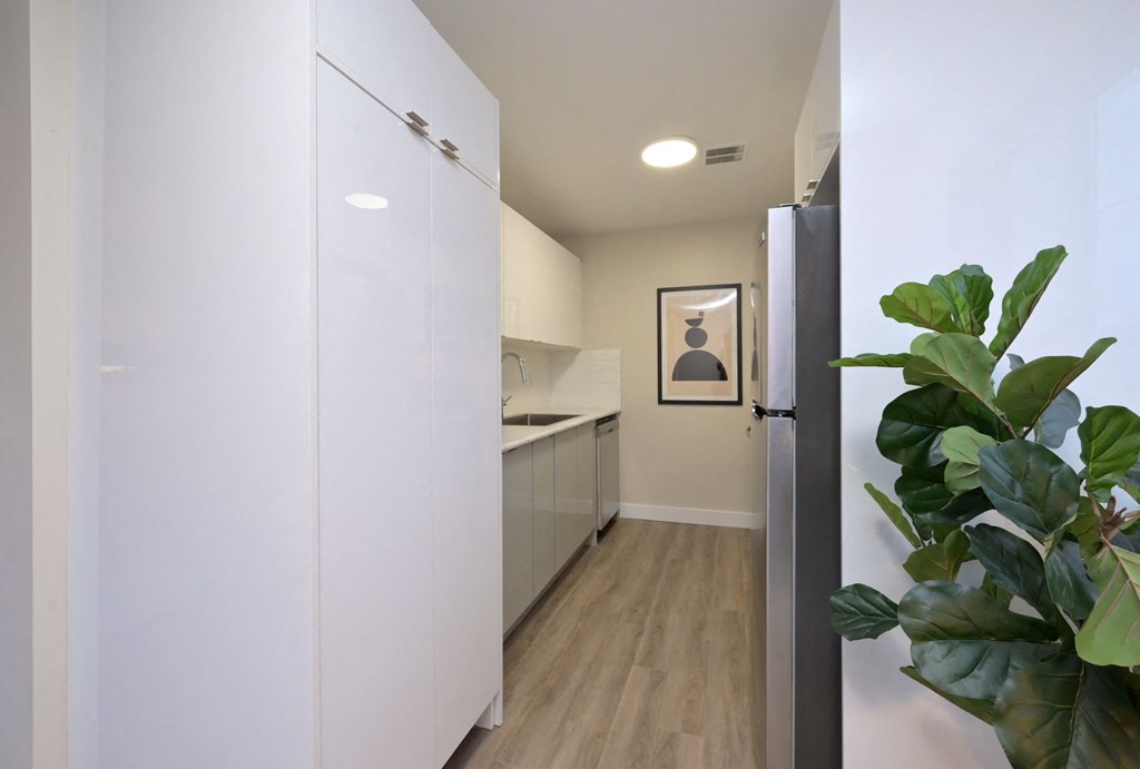 a kitchen with white cabinetry and a black refrigerator
