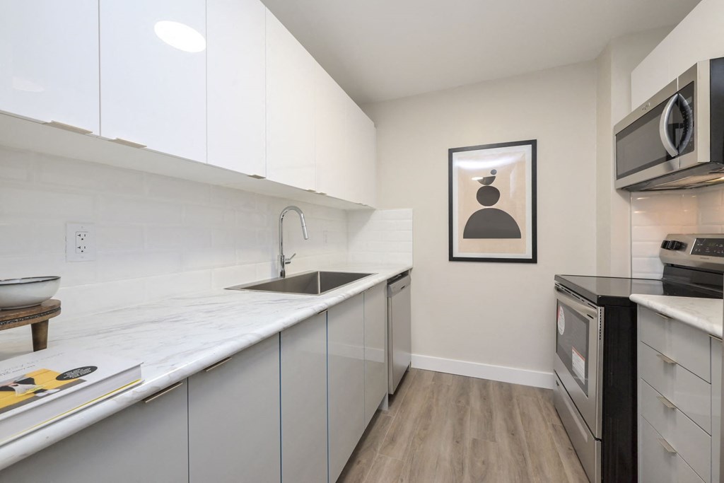 a kitchen with white cabinetry and a black stove top oven