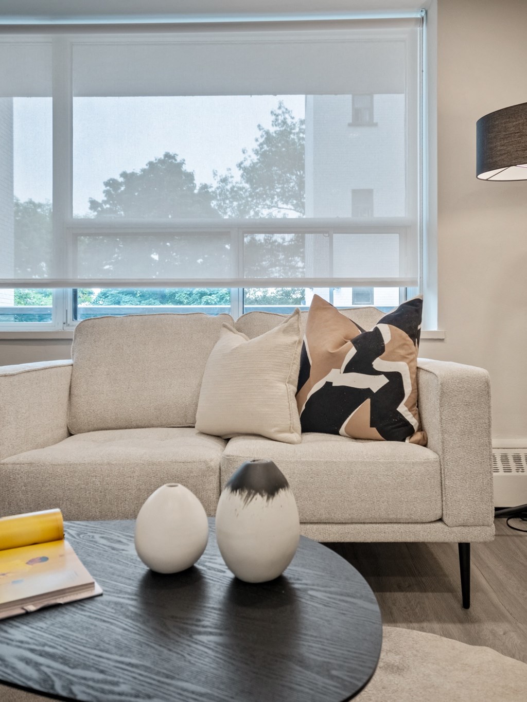 a living room with a couch and coffee table in front of a window