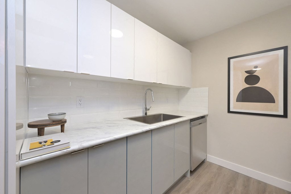 a kitchen with white cabinets and a sink
