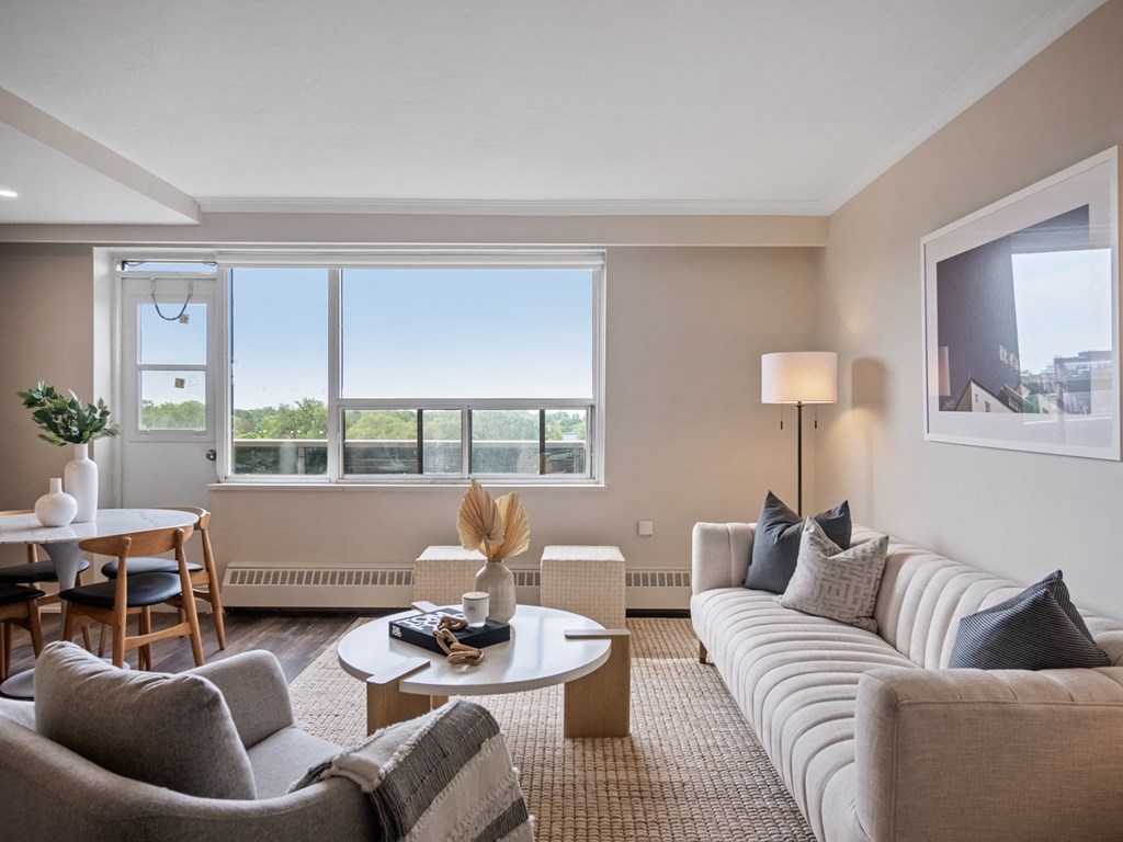 a living room with a white couch and a white coffee table in front of a large window