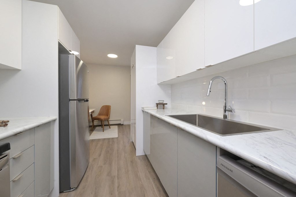 a kitchen with white cabinetry and a stainless steel sink