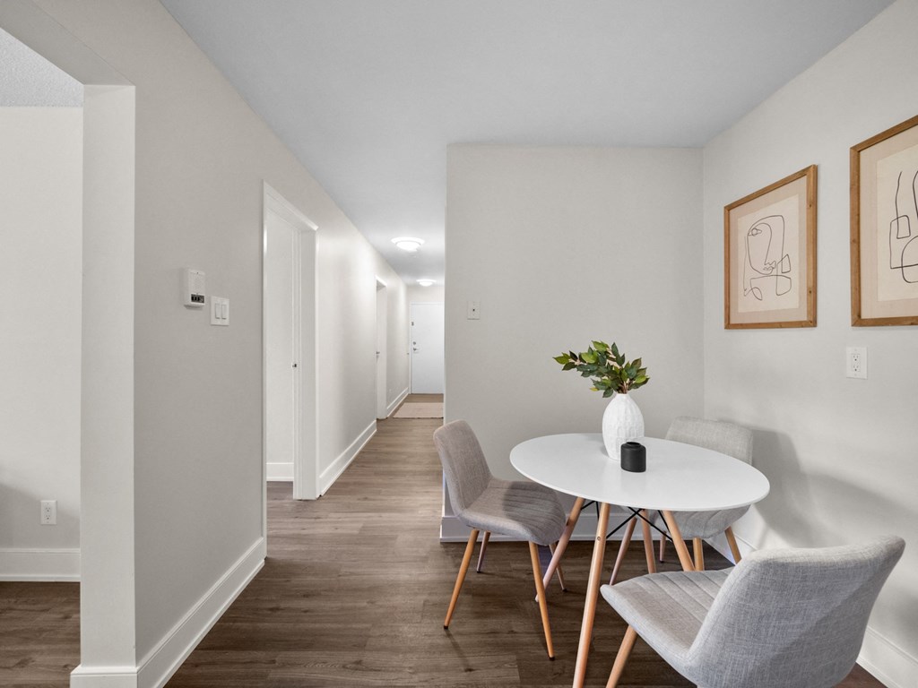 a dining area with a round table and three chairs