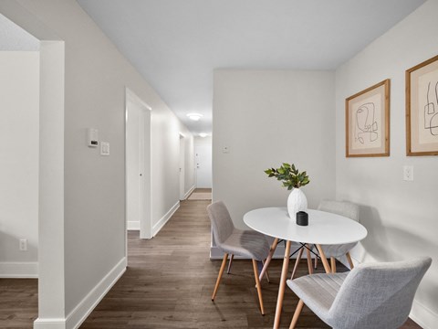 a dining area with a round table and three chairs