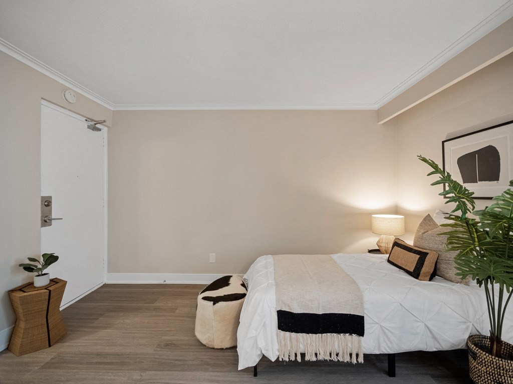 a bedroom with a bed and a potted plant