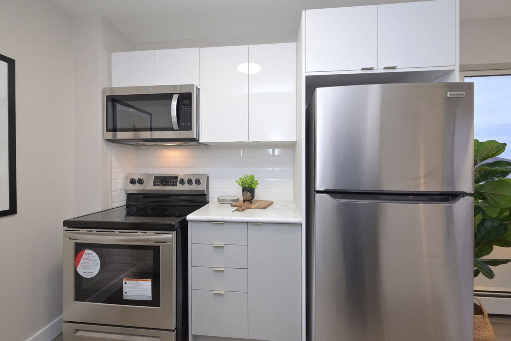 a small kitchen with white cabinets and stainless steel appliances