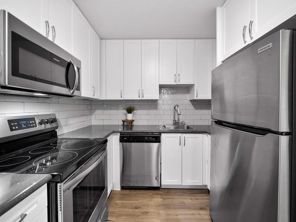 a kitchen with white cabinets and stainless steel appliances