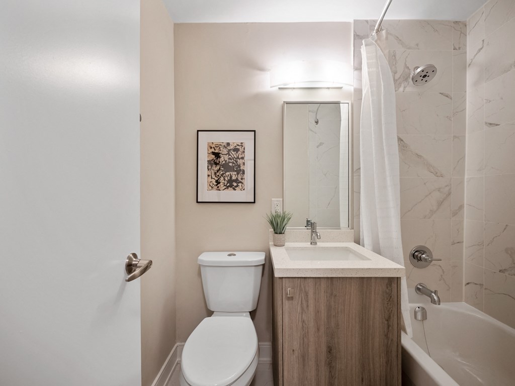 a bathroom with a toilet sink and tub in a 555 waverly unit