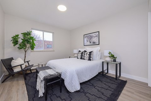 a bedroom with a large bed and a chair in a 555 waverly unit
