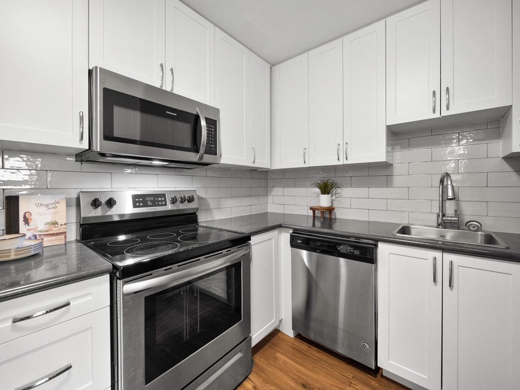 a kitchen with white cabinets and stainless steel appliances