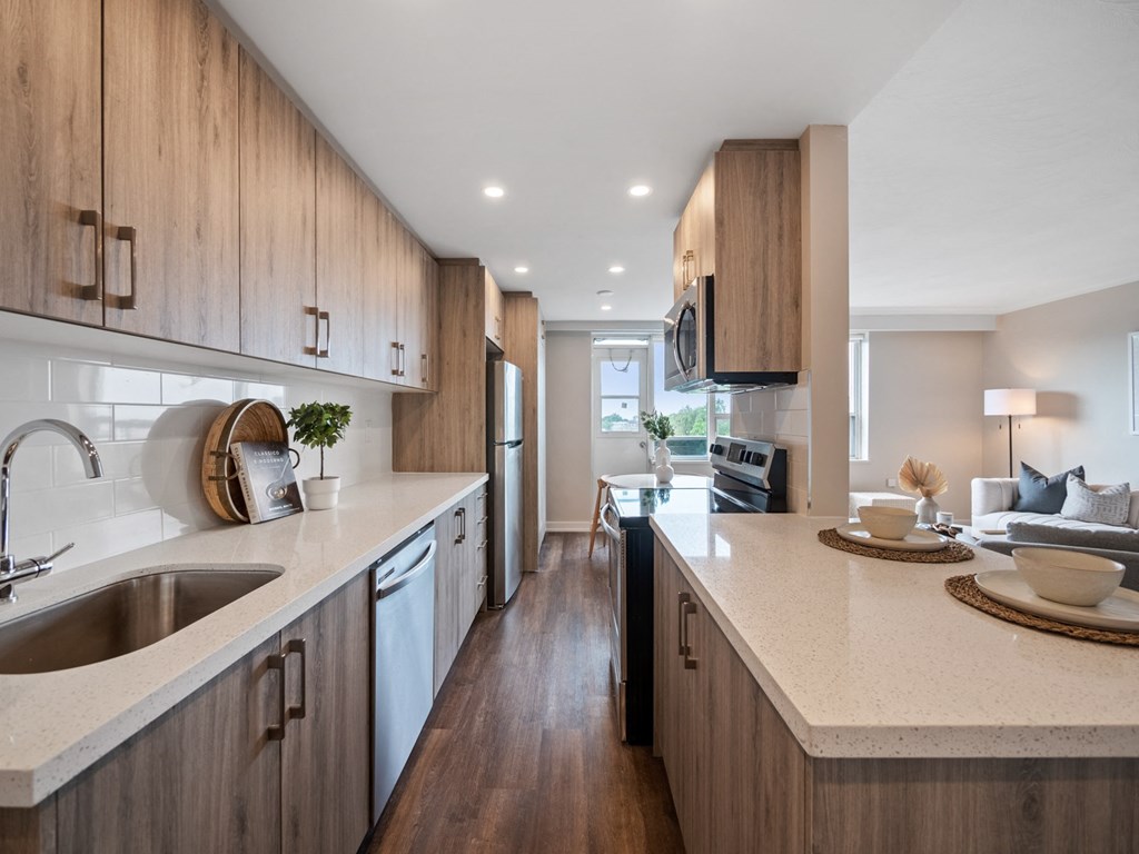 a kitchen with wooden cabinets and a large island with a sink and a dishwasher