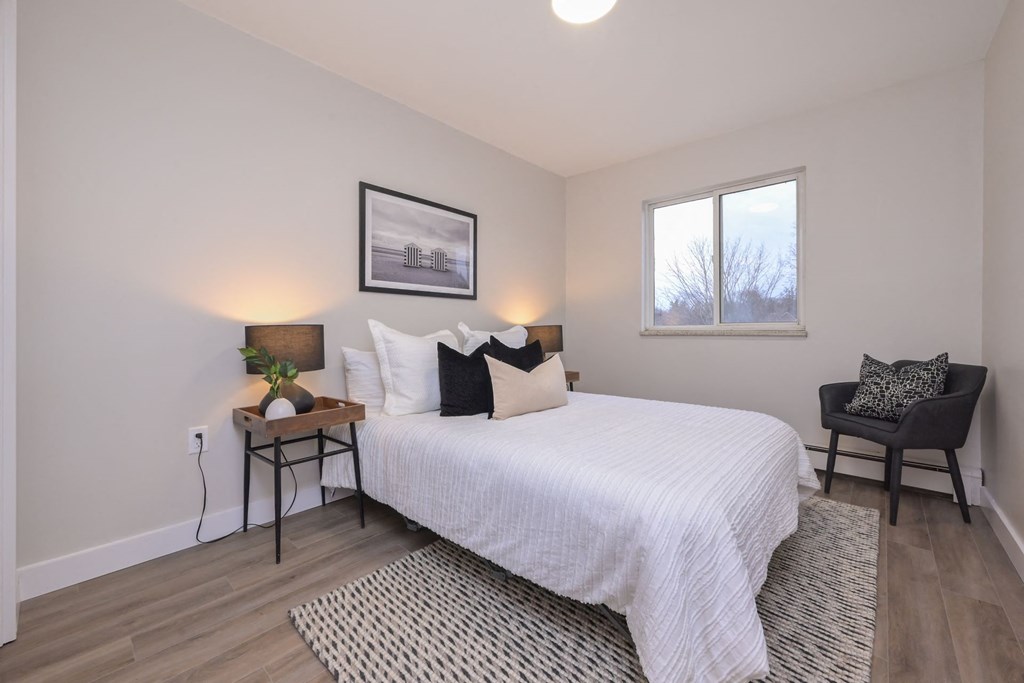 a bedroom with a bed and two windows