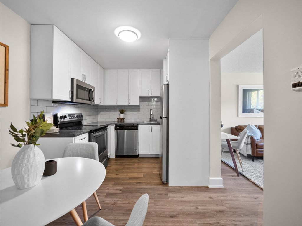 a kitchen with white cabinetry and black countertops