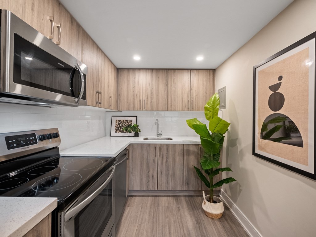 a kitchen with wood cabinetry and white countertops