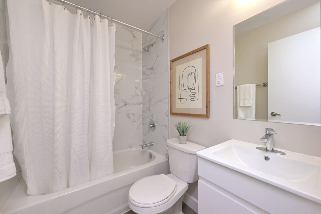 a bathroom with a white sink and toilet next to a bathtub with a shower curtain