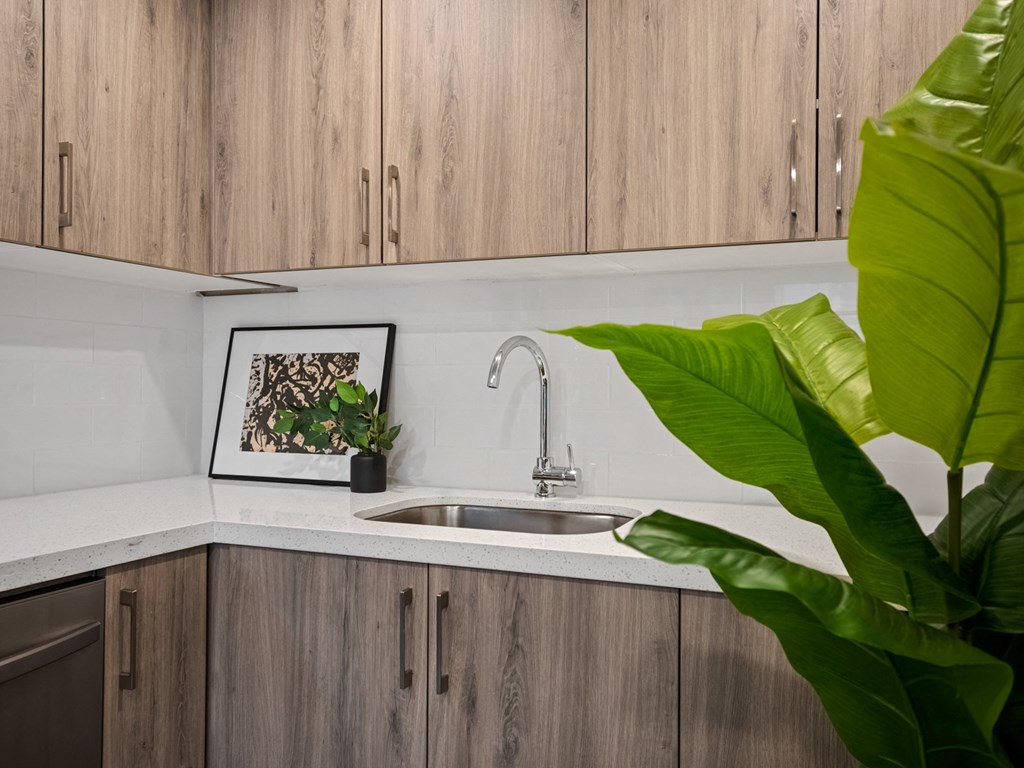 a kitchen with white countertops and wood cabinets
