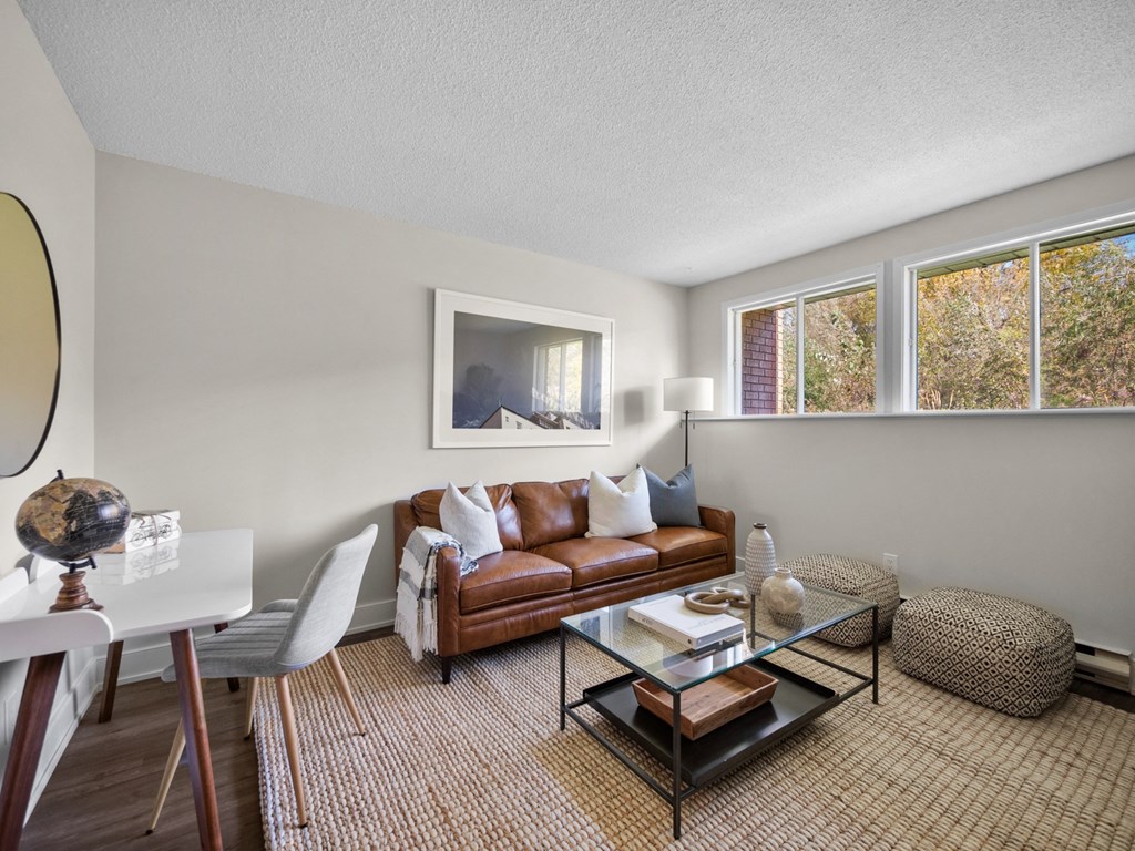 a living room with a brown couch and a glass coffee table