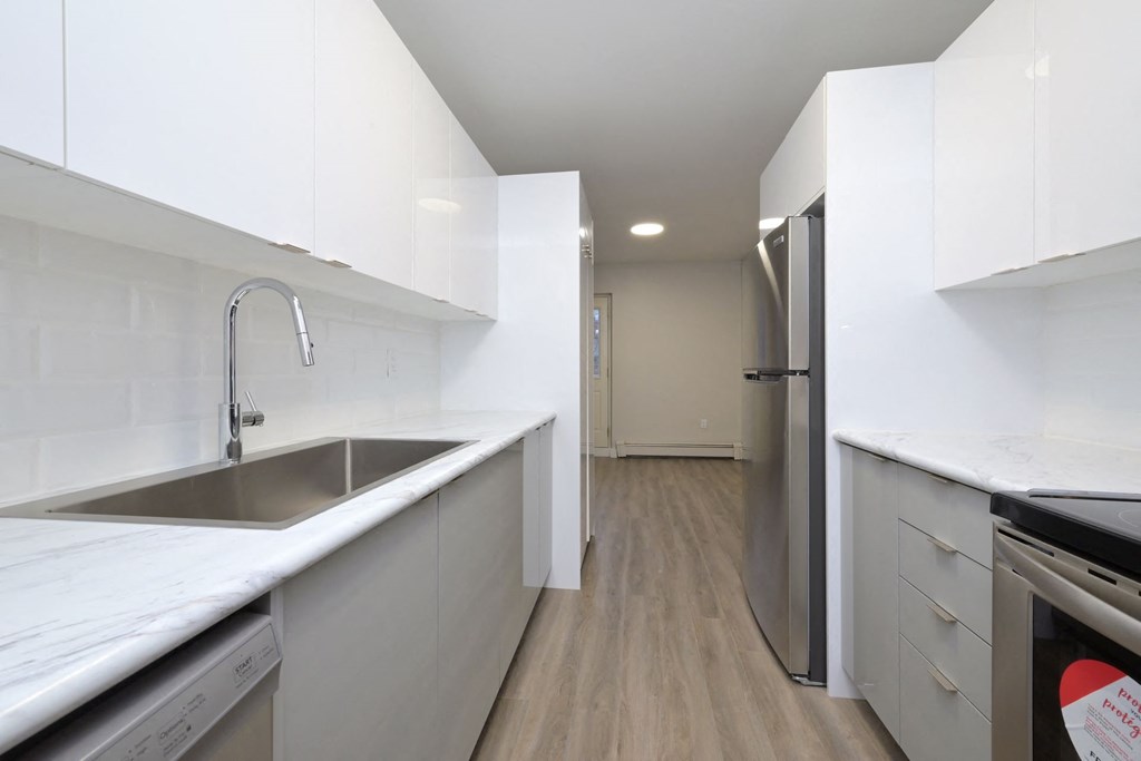 a kitchen with white cabinetry and a stainless steel sink