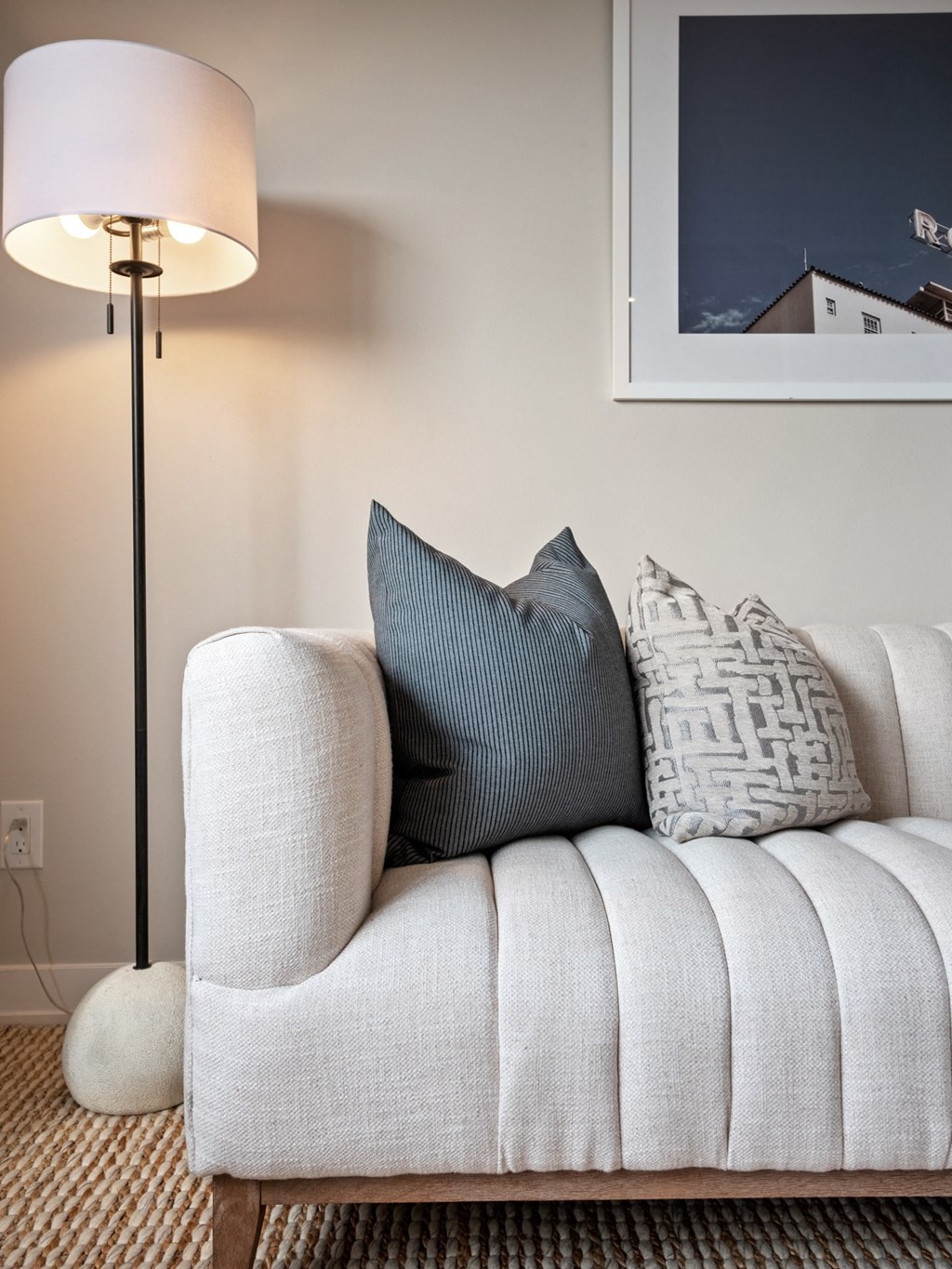 a couch with pillows and a floor lamp in a living room