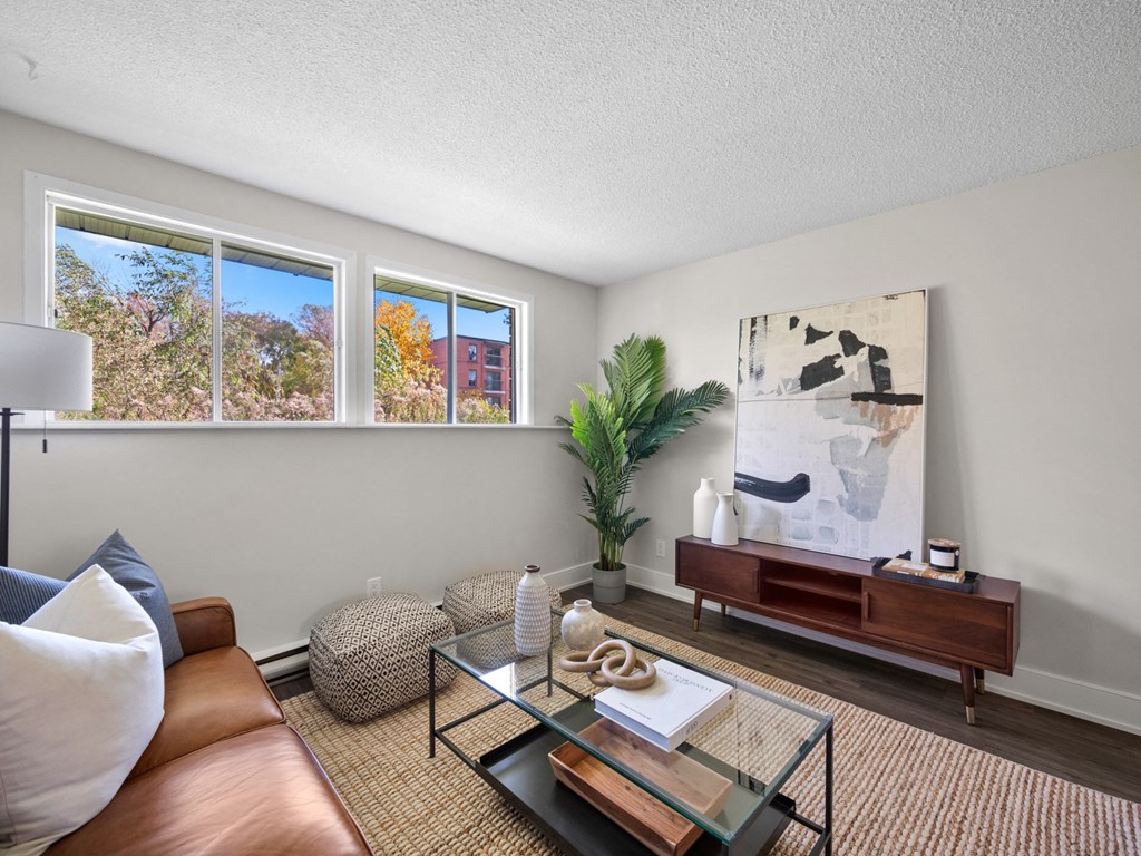 a living room with a glass coffee table and brown couch