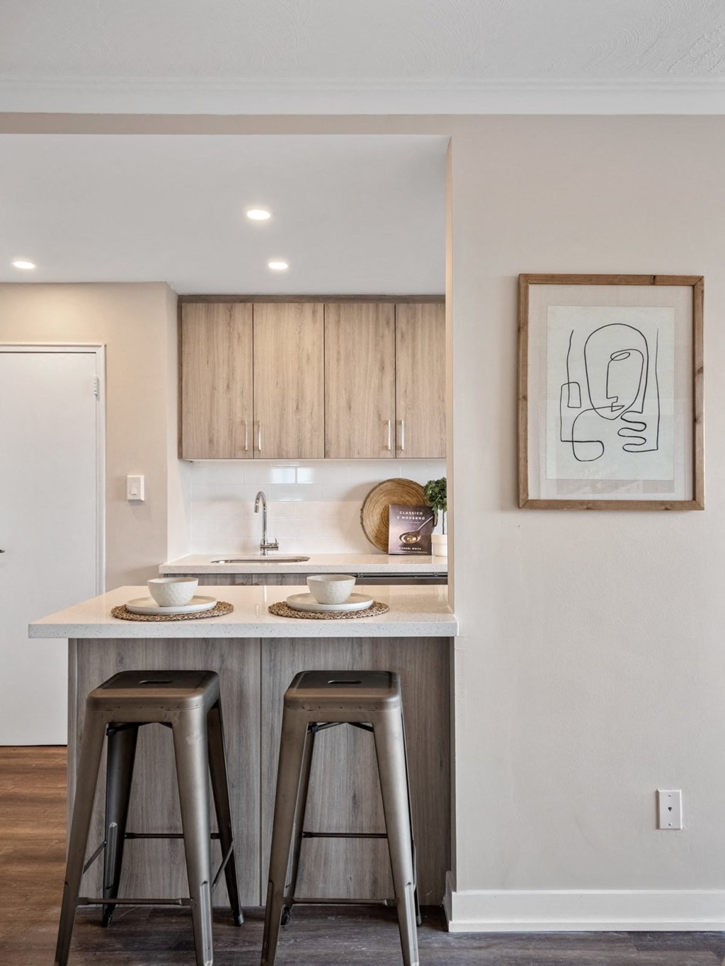 a kitchen with wooden cabinets and a counter with two stools