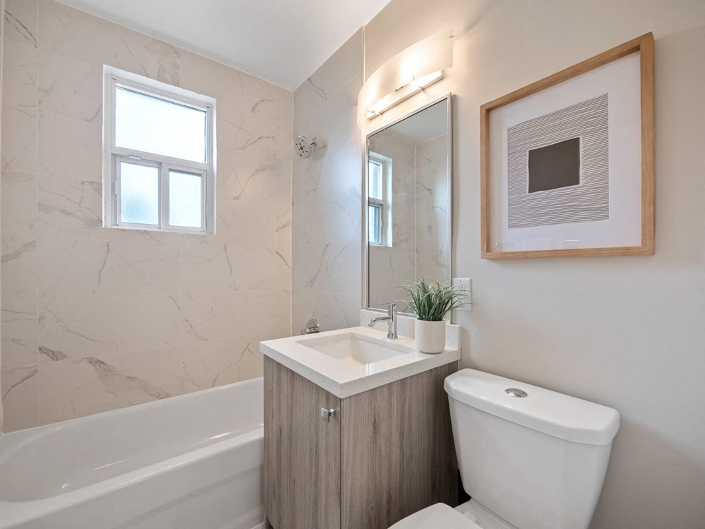 a bathroom with a toilet sink and bathtub in a 555 waverly unit