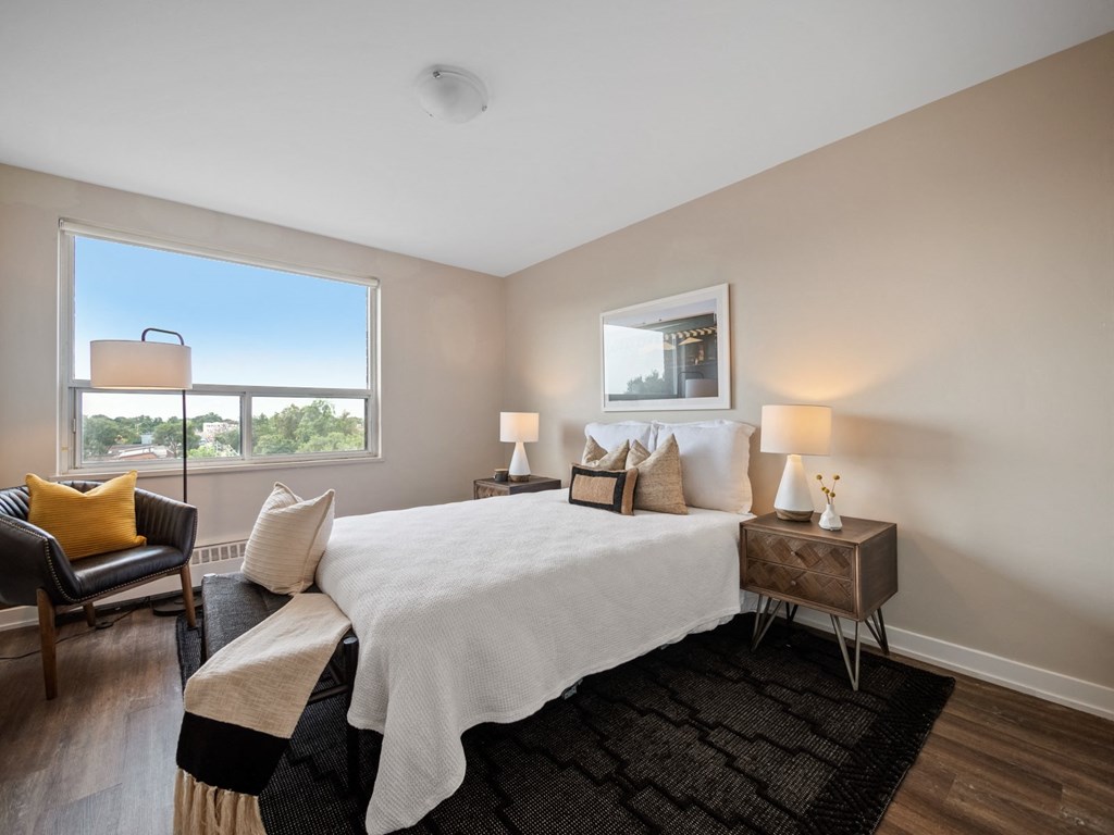 a bedroom with a bed and a chair in a room