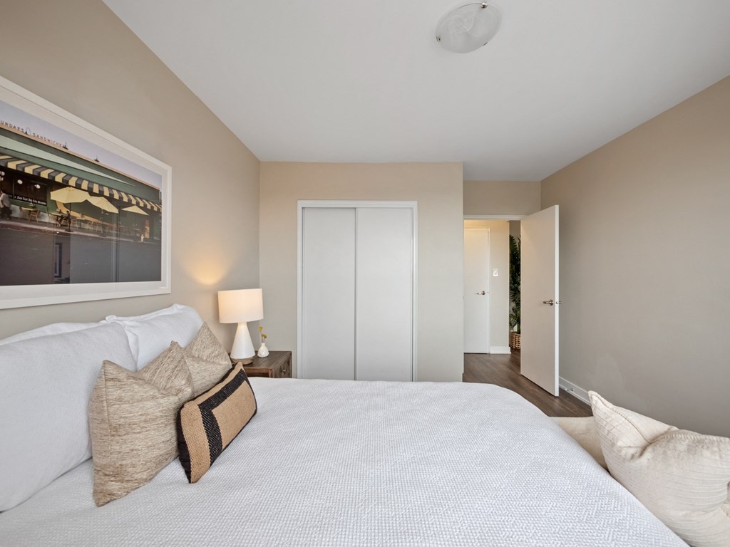 a bedroom with a large bed and a window with a view of the hallway