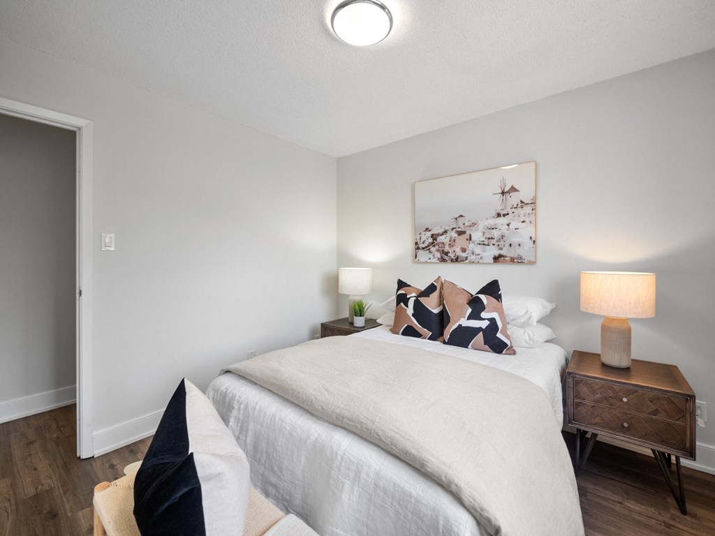 a bedroom with a bed and a nightstand with a lamp