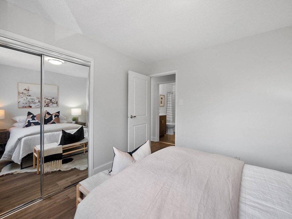 a bedroom with a large bed and a large mirror