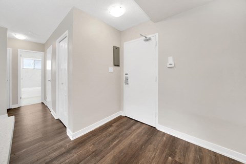 a bedroom with hardwood flooring and white walls